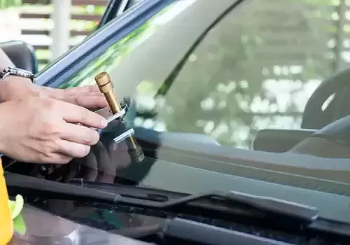 Glass Ding supports mobile service when a technician in a yellow vest checks the car.